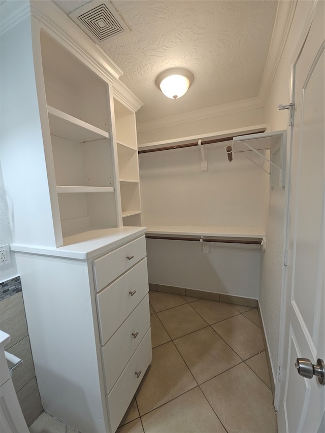 walk in closet with light tile patterned floors