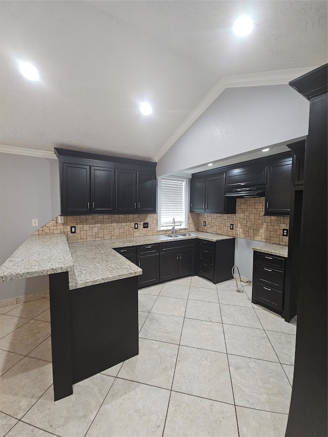 kitchen featuring light tile patterned floors, sink, kitchen peninsula, crown molding, and vaulted ceiling