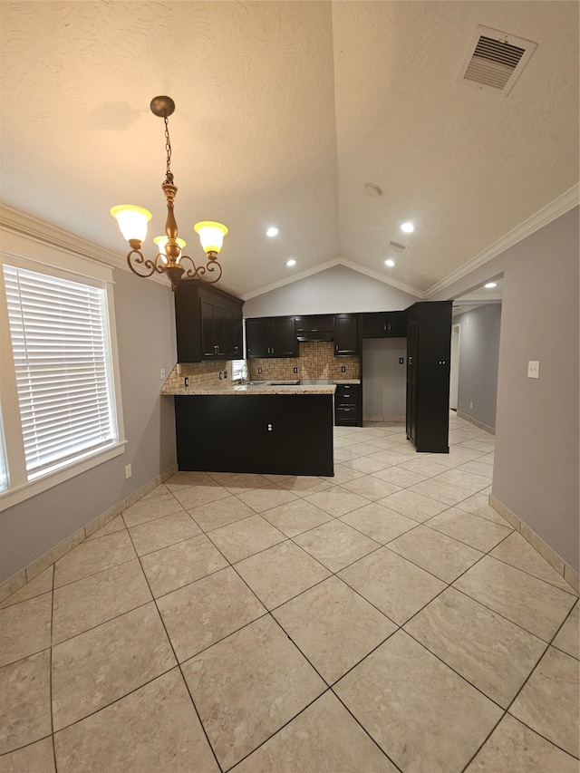 kitchen with pendant lighting, vaulted ceiling, kitchen peninsula, an inviting chandelier, and crown molding