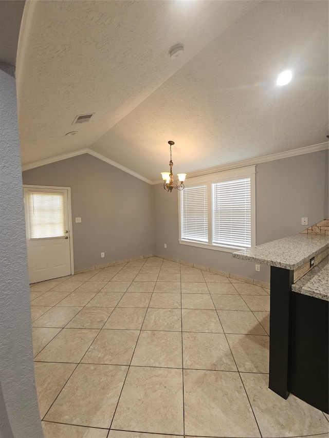 interior space with a textured ceiling, lofted ceiling, ornamental molding, and an inviting chandelier