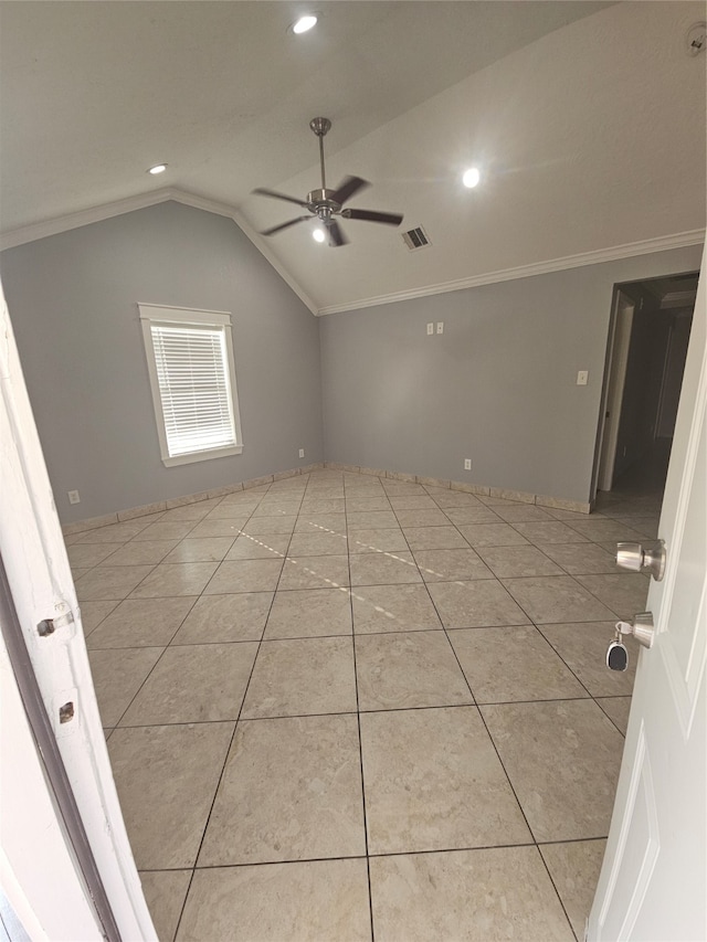 spare room featuring lofted ceiling, ceiling fan, light tile patterned flooring, and crown molding