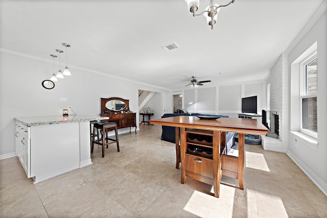 office area featuring ceiling fan with notable chandelier, a fireplace, and ornamental molding