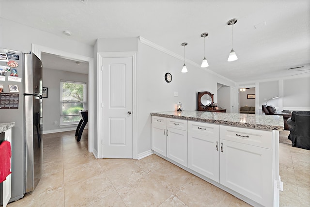 kitchen featuring hanging light fixtures, stainless steel fridge, white cabinetry, light stone countertops, and ornamental molding