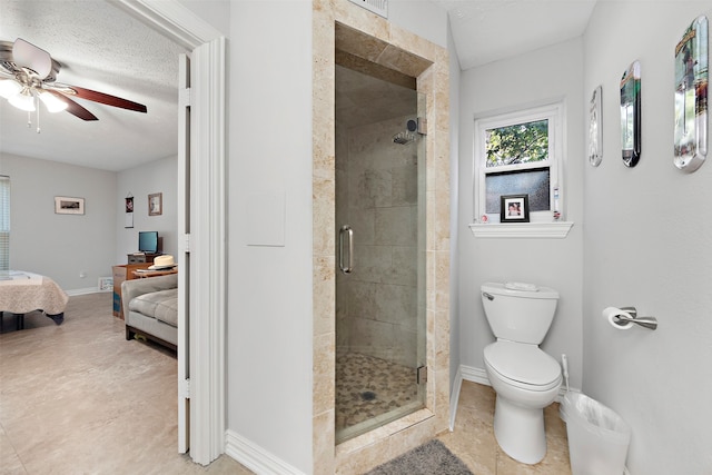 bathroom with a textured ceiling, ceiling fan, a shower with shower door, and toilet