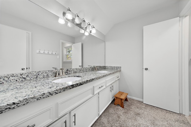 bathroom with lofted ceiling and vanity