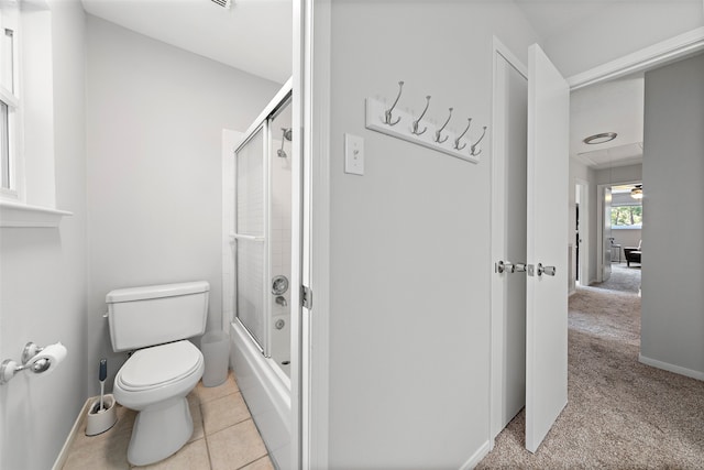 bathroom with tile patterned flooring, combined bath / shower with glass door, and toilet