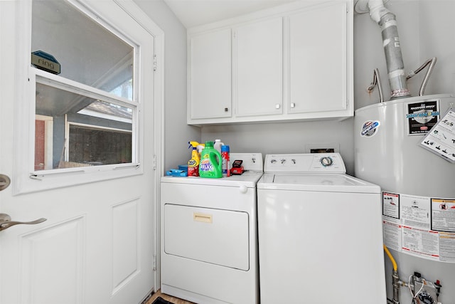 clothes washing area with gas water heater, cabinets, and washer and dryer