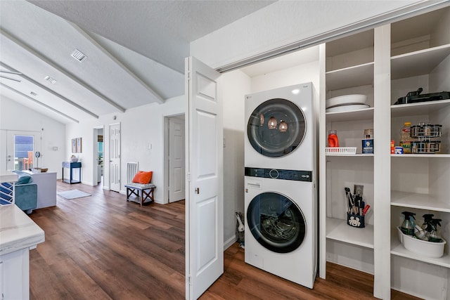 washroom featuring stacked washer and clothes dryer, a textured ceiling, and dark hardwood / wood-style floors