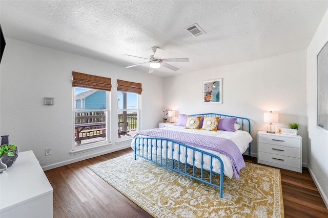 bedroom featuring a textured ceiling, ceiling fan, and dark hardwood / wood-style flooring