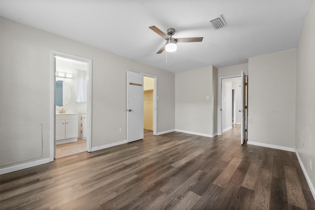 unfurnished bedroom featuring connected bathroom, ceiling fan, and dark wood-type flooring