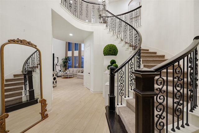 entrance foyer with a towering ceiling and hardwood / wood-style floors