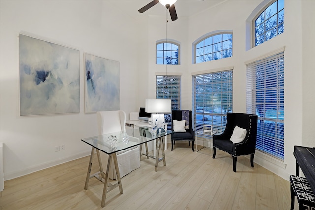 office area featuring a high ceiling, light hardwood / wood-style floors, and ceiling fan