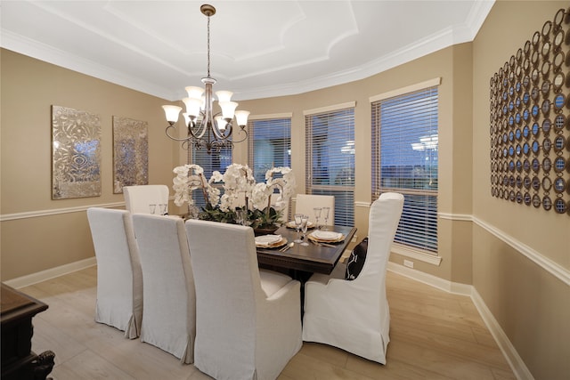 dining area featuring ornamental molding, light hardwood / wood-style flooring, and a chandelier