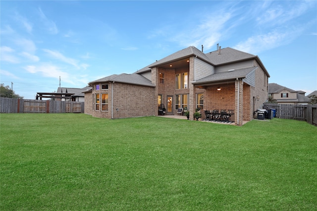 back of house featuring a lawn and a patio