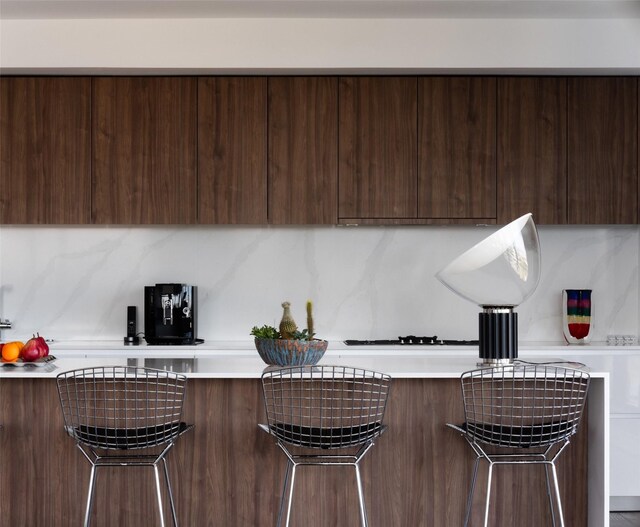 kitchen featuring dark brown cabinetry and a breakfast bar area