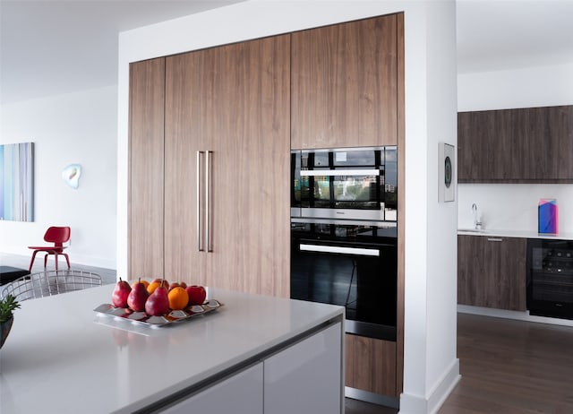 kitchen with wine cooler, sink, stainless steel appliances, and dark wood-type flooring