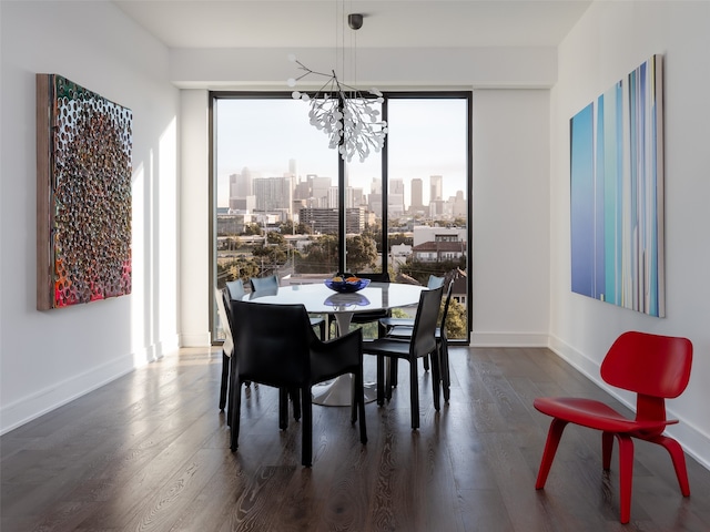 dining area with dark wood-type flooring and a notable chandelier