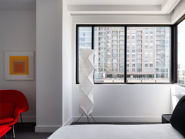 bedroom featuring dark carpet and multiple windows