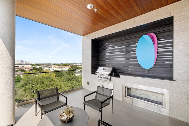 view of patio featuring area for grilling, a balcony, and an outdoor kitchen