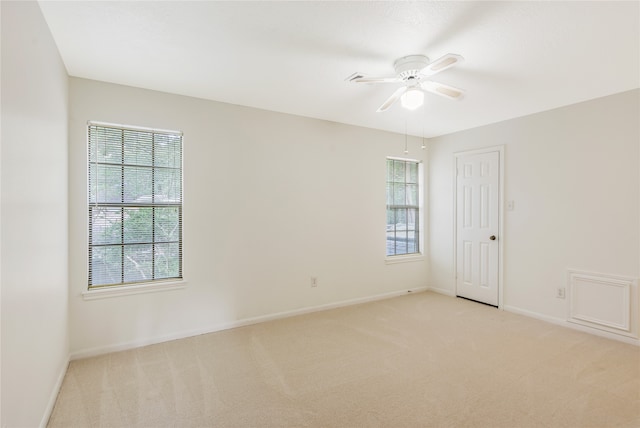 empty room featuring ceiling fan and light colored carpet