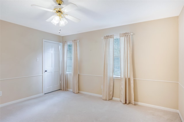 carpeted empty room featuring a wealth of natural light and ceiling fan