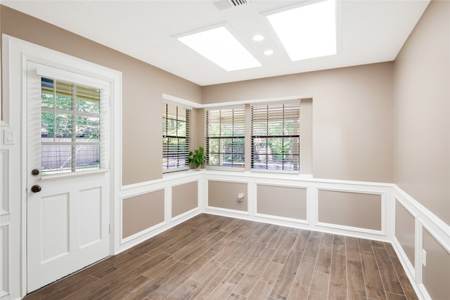 empty room with a skylight and wood-type flooring