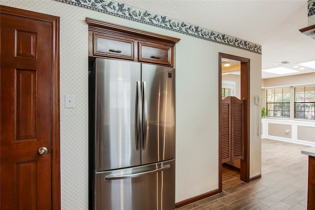 kitchen featuring dark hardwood / wood-style floors, stainless steel fridge, and a textured ceiling