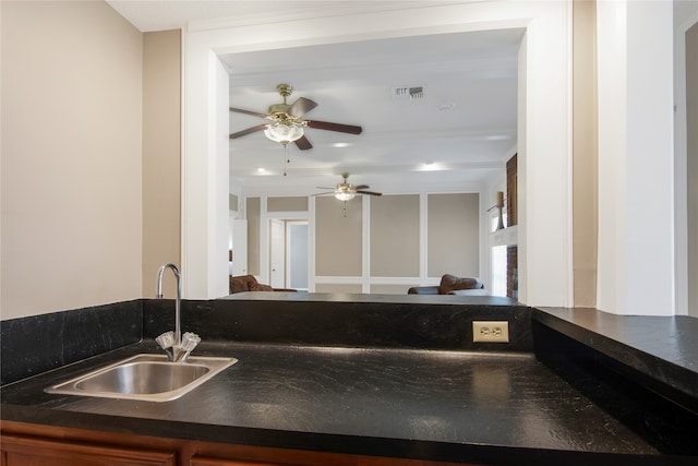 kitchen with ceiling fan, ornamental molding, and sink