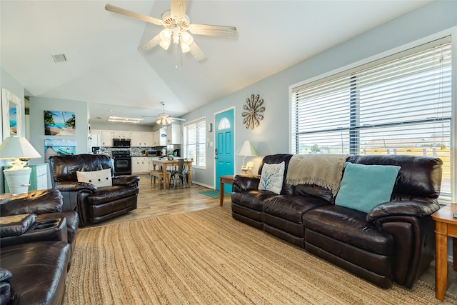 living room with high vaulted ceiling, light hardwood / wood-style flooring, ceiling fan, and plenty of natural light