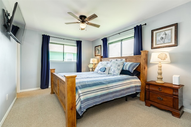 bedroom featuring multiple windows, ceiling fan, and light colored carpet