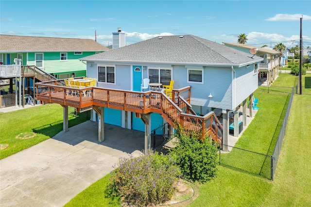 rear view of house with a wooden deck and a yard