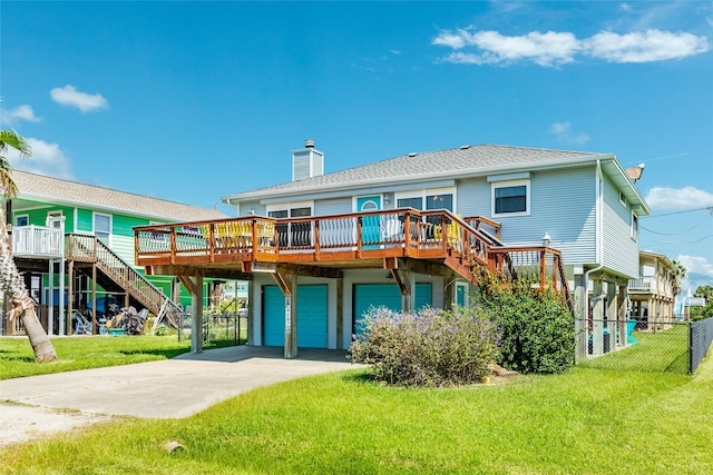 back of house with a lawn, a deck, and a garage