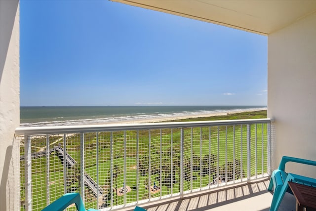 balcony with a water view and a view of the beach