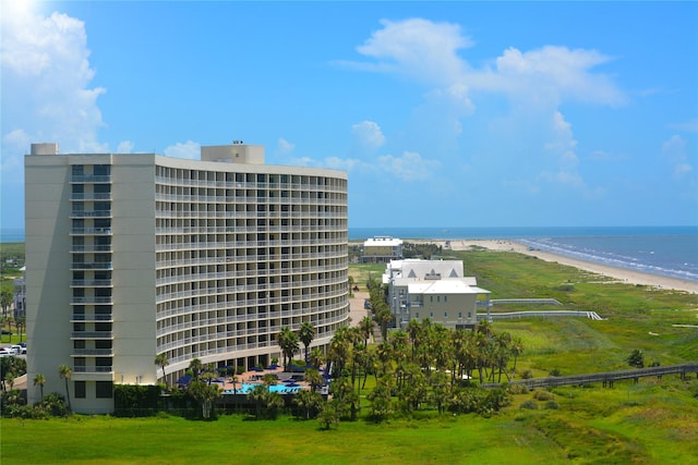 view of building exterior with a beach view and a water view