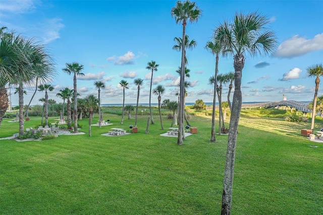 view of home's community featuring a lawn and a water view