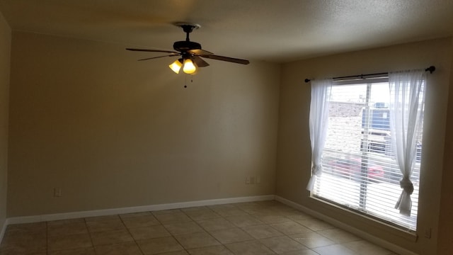 tiled spare room with ceiling fan and a wealth of natural light