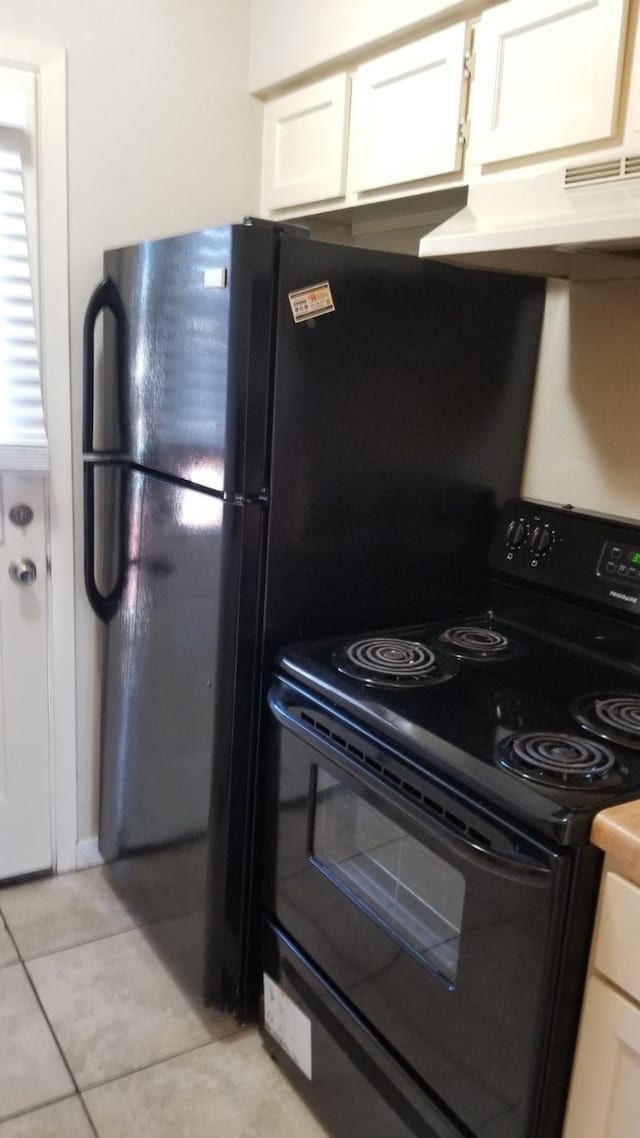 kitchen with white cabinets, light tile patterned flooring, black electric range, and ventilation hood