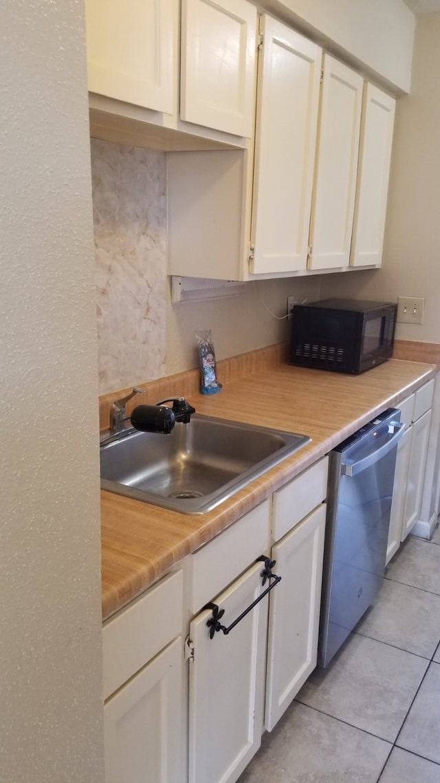 kitchen with white cabinetry, dishwasher, and sink