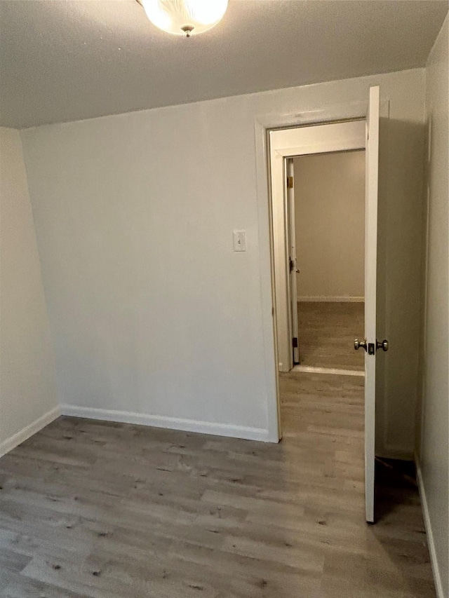 spare room with wood finished floors and baseboards