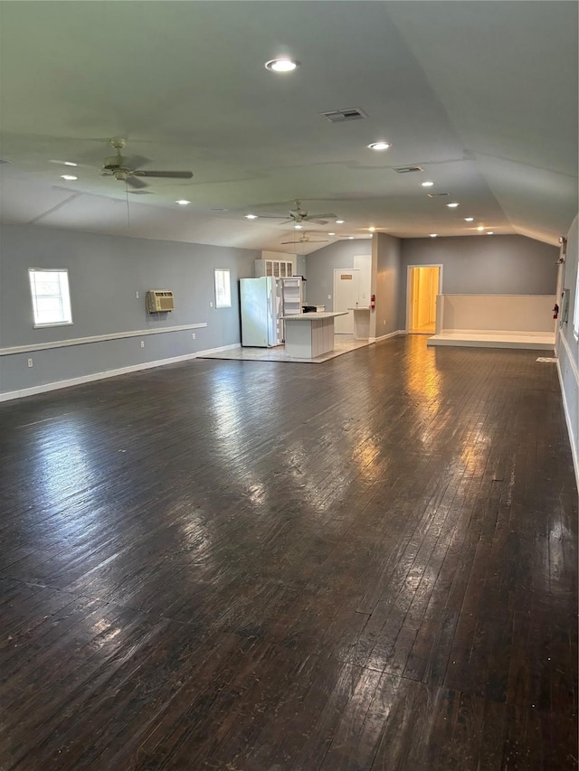 unfurnished living room featuring ceiling fan, hardwood / wood-style floors, visible vents, and baseboards