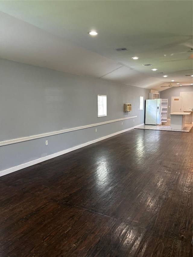 unfurnished living room featuring recessed lighting, visible vents, baseboards, vaulted ceiling, and hardwood / wood-style floors