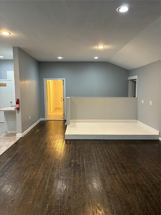 interior space with lofted ceiling, wood-type flooring, baseboards, and recessed lighting