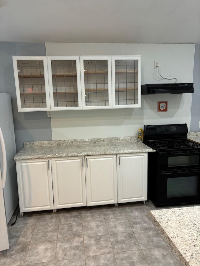 kitchen with range with two ovens, glass insert cabinets, freestanding refrigerator, under cabinet range hood, and white cabinetry