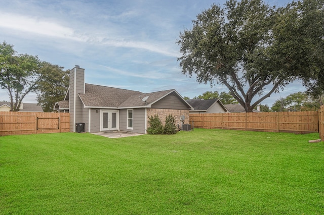 rear view of property featuring cooling unit and a yard