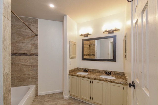 bathroom featuring tiled shower / bath combo and vanity