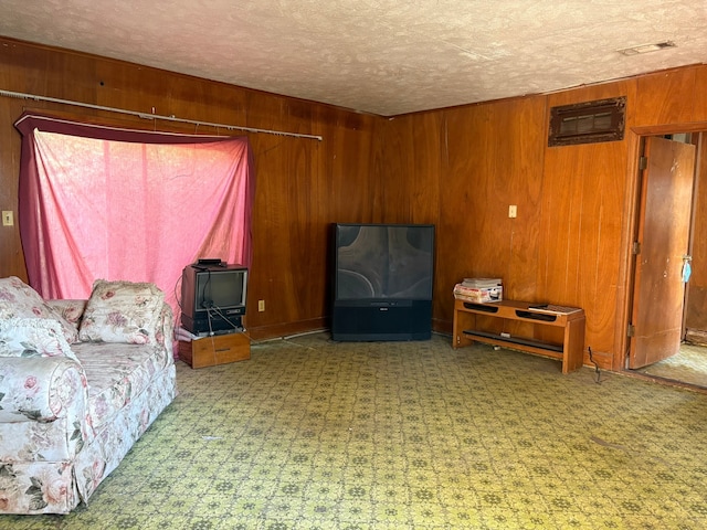 living room featuring a textured ceiling and wooden walls