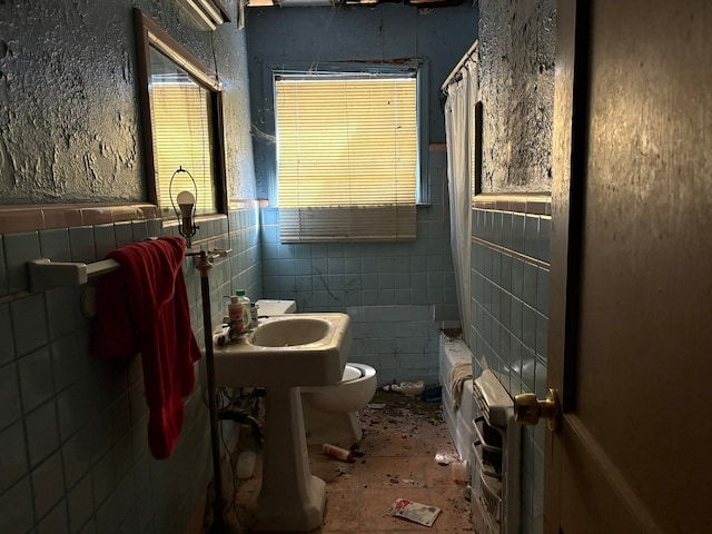 bathroom featuring tile walls, shower / bath combo, and toilet