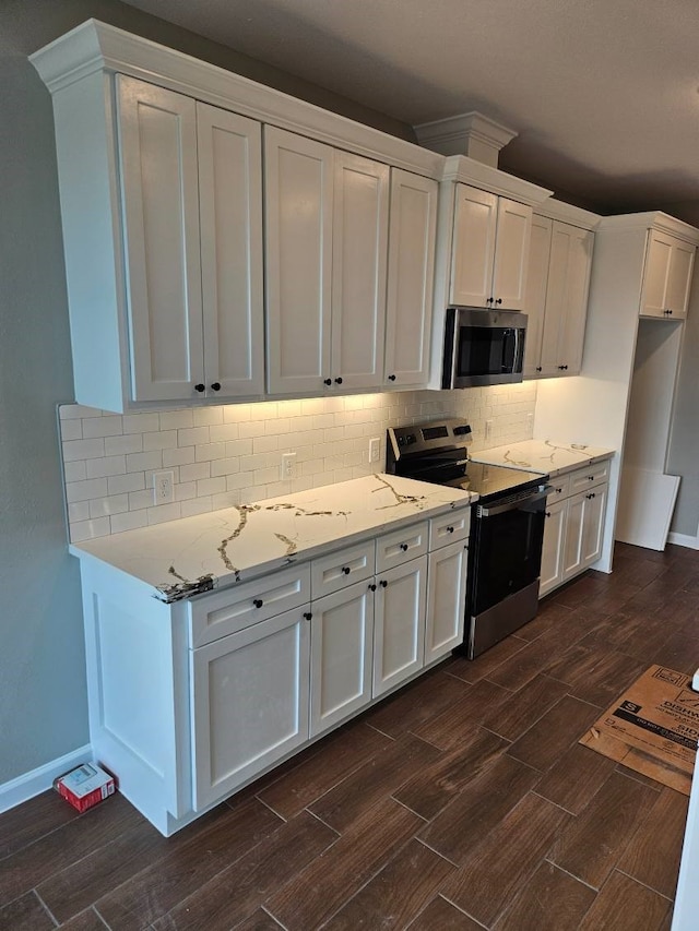 kitchen featuring white cabinets, dark hardwood / wood-style floors, appliances with stainless steel finishes, and tasteful backsplash