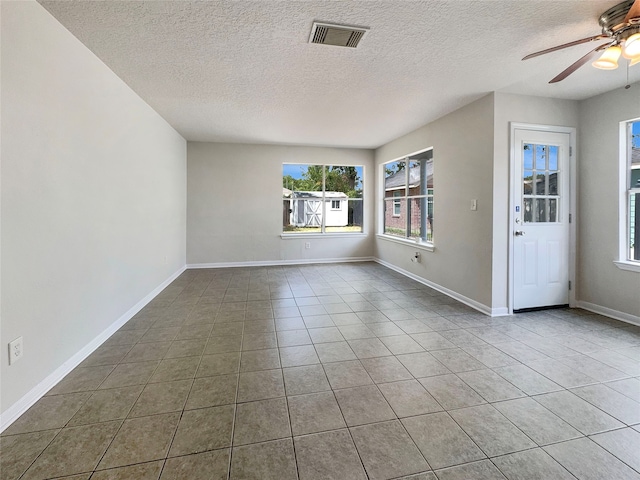 unfurnished room featuring ceiling fan, a textured ceiling, and tile patterned floors