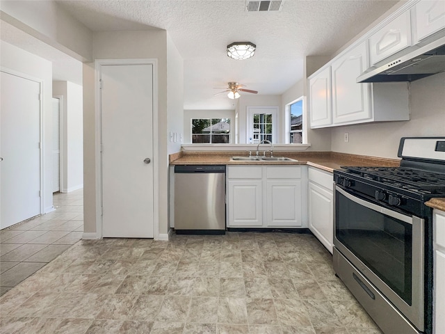 kitchen featuring sink, white cabinets, appliances with stainless steel finishes, extractor fan, and ceiling fan